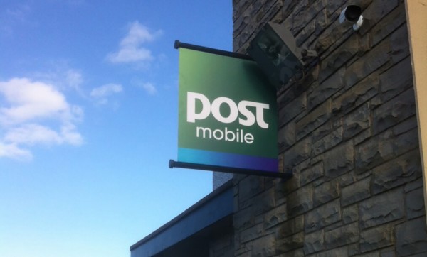 A Wall mounted projecting sign displayed outside an an Post