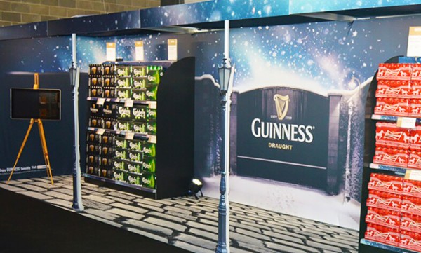 An exhibitions display for guinness that depicts the gates of the guinness brewery with a cobblestone printed carpet