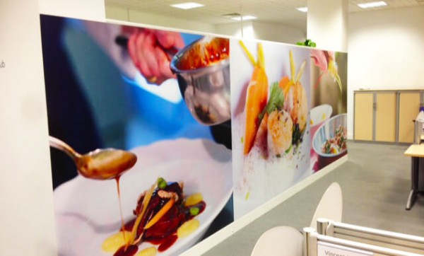 wall graphic in an office depicting a person dripping sauce on a meal and vegetables