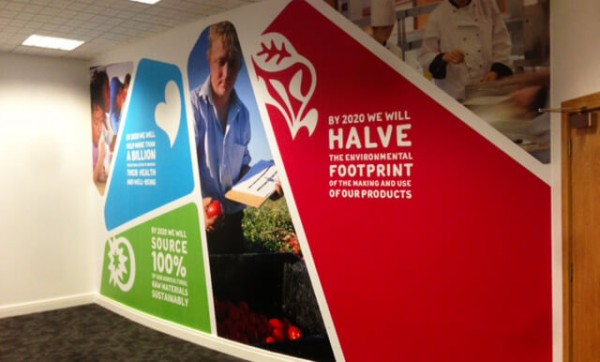 wall graphic in an office showing a man reading in a field holding fruit