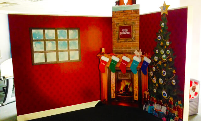 wall graphic in an office depicting a christmas scene with a tree, a fireplace and christmas stockings